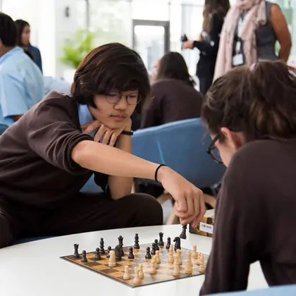Two students concentrating over a chess board